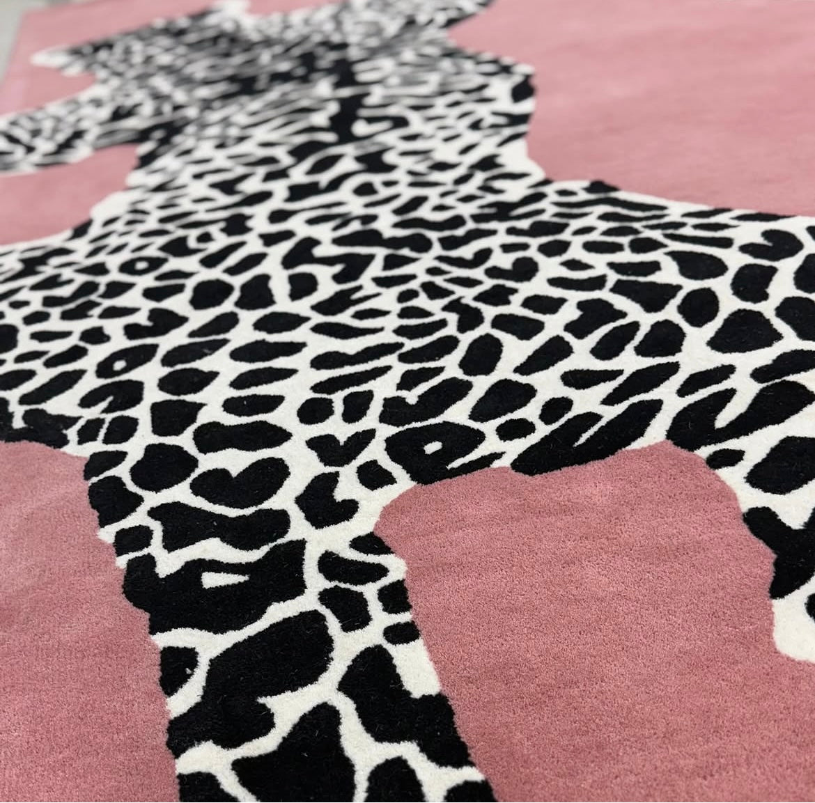 Handgetufter Design-Teppich mit wildem Leoparden-Motiv in Altrosa & Schwarz-Weiß